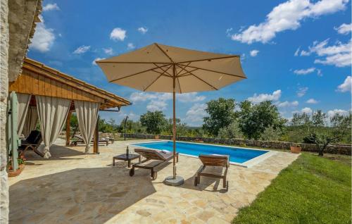 Una sombrilla y sillas junto a una piscina. en Villa Jerolim, en Zadar