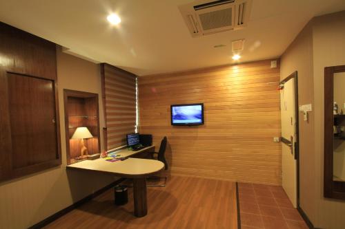 a room with a desk and a tv on a wall at Ming Paragon Hotel in Kuala Terengganu