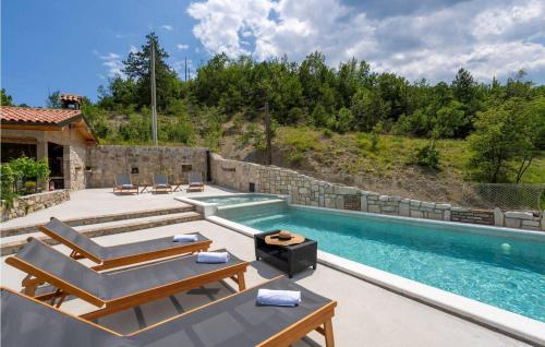 a swimming pool with lounge chairs and a house at Casa Zamarija in Labin