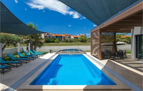 una piscina con sedie a sdraio accanto a una casa di Villa Lena Lux a Pola (Pula)
