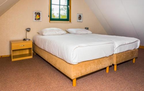 a bedroom with a large bed with a night stand at Gorgeous Home In Ijhorst With Wifi in IJhorst