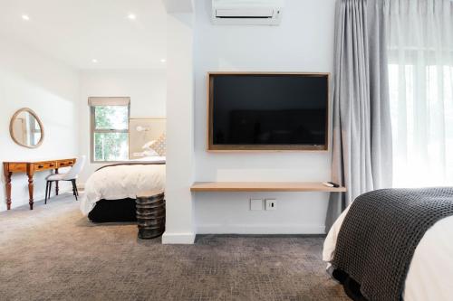 a hotel room with a flat screen tv on a wall at Vineyard Hotel in Cape Town