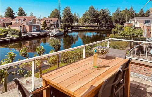 a wooden table on a balcony with a view of a river at Lisdodde in Workum