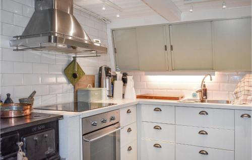 a kitchen with white cabinets and a stove at Amazing Home In Kivik With Wifi in Kivik
