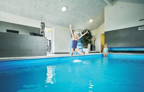 Una donna che salta in una piscina di Eight-Bedroom Holiday Home Frederiksværk With A Room Hot Tub 03 a Melby