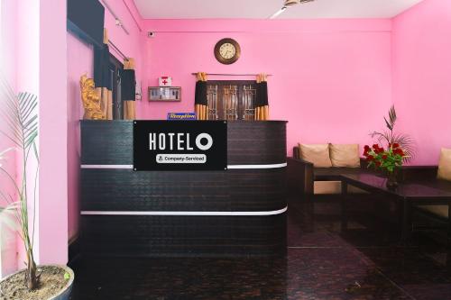 a hotel lobby with pink walls and a clock at Super Hotel O Sarvodaya Nagar Near Railway Station in Puri