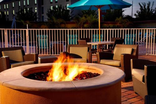 a fire pit in a patio with chairs and an umbrella at Residence Inn Tampa Oldsmar in Oldsmar