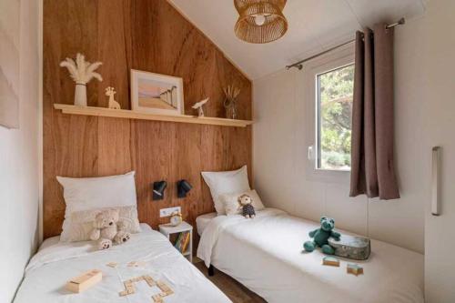 Deux lits dans une pièce avec des animaux farcis dans l'établissement Camping 4 étoiles - Piscine - cbgcaig, à Notre-Dame-de-Monts