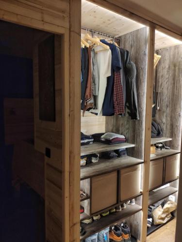 - un dressing rempli de vêtements et de chaussures dans l'établissement La Cabane Charmant T2 avec jardin centre village, à Saint-Gervais-les-Bains
