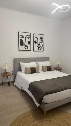 a bedroom with a large bed with three pictures on the wall at Sias Apartment in Alexandroupoli