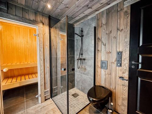 a bathroom with a shower and a stool in it at Modern Mountain Cabin - Sauna - 5 Bedrooms - Sleeps for 10 in Torpo