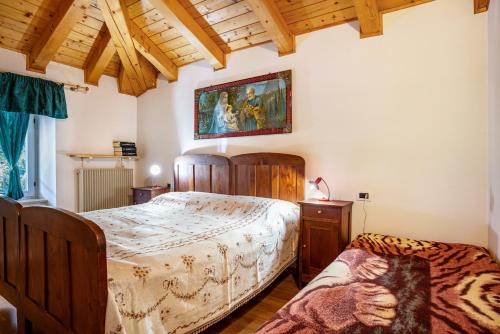 a bedroom with a bed and a painting on the wall at Casa Ai Laresi 2 in Peio