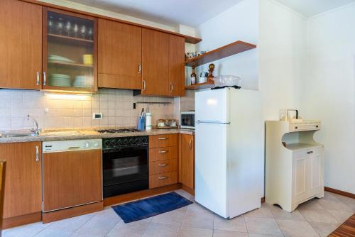 a kitchen with a white refrigerator and wooden cabinets at Casa Ai Laresi 1 in Peio
