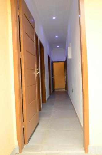 an empty hallway with an open door and a corridorngthngthngthngthngthngth at Maison de la Volonté Divine, Simple et empreint de sérénité in Abomey-Calavi