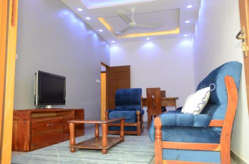 a living room with two chairs and a tv at Maison de la Volonté Divine, Simple et empreint de sérénité in Abomey-Calavi