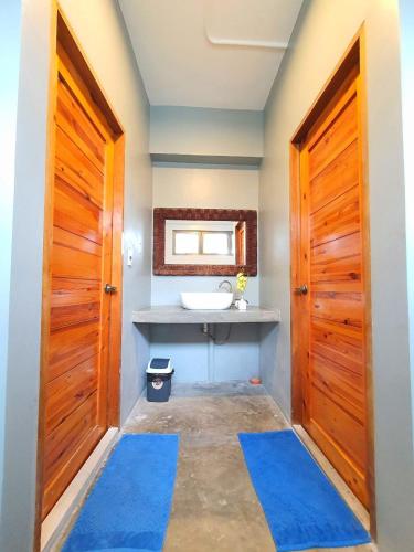 a bathroom with a sink and a wooden door at AV Suites in Puerto Galera
