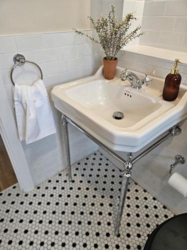 a bathroom with a white sink and a black and white floor at Three bedroom cosy quiet luxury in the Burren Wild Atlantic Way in Galway