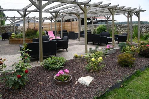 a patio with chairs and flowers in a garden at Logis Auberge De Launay in Limeray