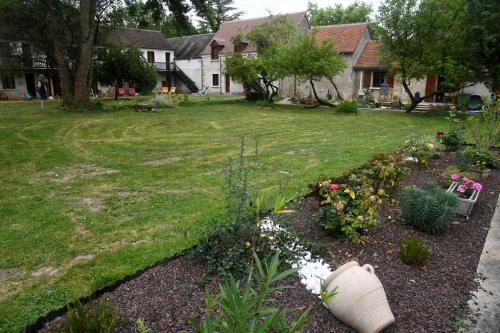 a garden with flowers and plants in a yard at Logis Auberge De Launay in Limeray