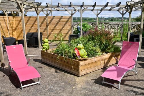 two pink chairs and a wooden planter with plants at Logis Auberge De Launay in Limeray
