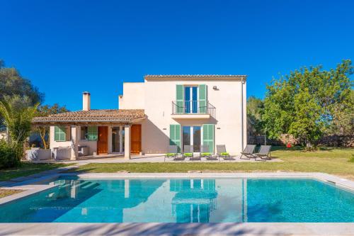 a villa with a swimming pool in front of a house at Ses Set Tanques de Son Fosquet in Llucmajor