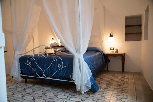 a bedroom with a blue bed with curtains at B&B Visìta_experience in Torre Santa Susanna