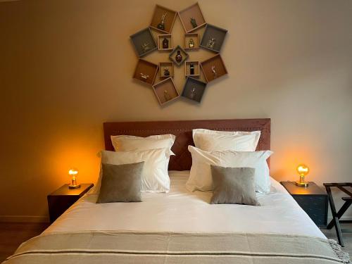 a bedroom with a bed with pillows and mirrors on the wall at Le Mas de Camassade in Tourrettes-sur-Loup