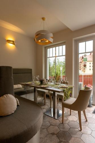 a living room with a table and a couch at Hotel Willa Odkrywców in Szklarska Poręba