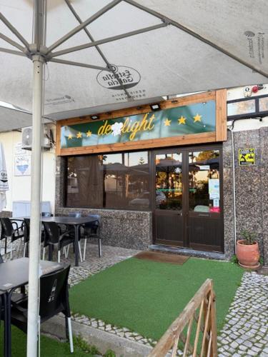 a restaurant with a green lawn in front of it at Beach, surf and golf apartment near Lisbon in Aroeira