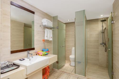 a bathroom with a sink and a shower and a toilet at Sanya Sun and Sea Gueshouse in Sanya