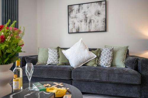 a living room with a couch with pillows and a table at Barmouth High Street Family Apartment in Barmouth
