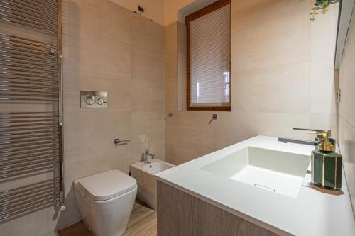 a bathroom with a white sink and a toilet at BGY Airport House-8 minuti dall'aeroporto in Orio al Serio