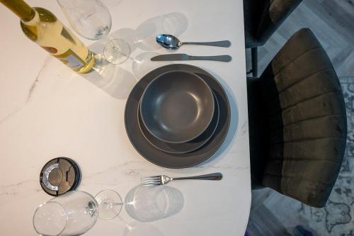 a table with a plate and wine glasses on it at Barmouth High Street Family Apartment in Barmouth