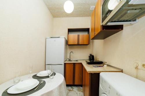 a small kitchen with a table and a refrigerator at Однокімнатна квартира біля ЦУМу в центрі Полтави Документи для відряджень Безконтатне заселення 24-7 in Poltava