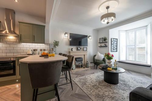 a kitchen and living room with a island in the middle at Barmouth High Street Family Apartment in Barmouth