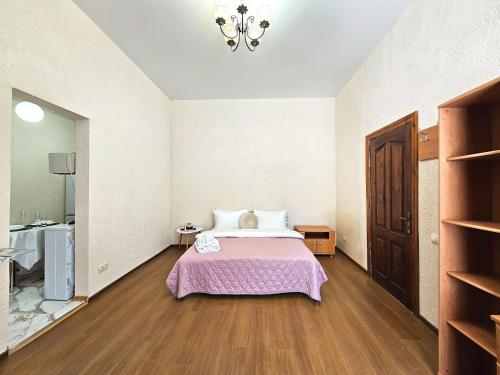 a bedroom with a bed with a pink blanket at Однокімнатна квартира біля ЦУМу в центрі Полтави Документи для відряджень Безконтатне заселення 24-7 in Poltava