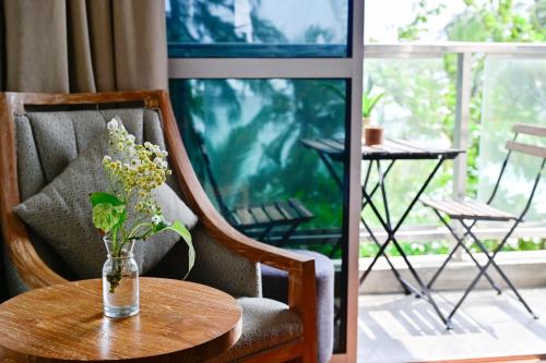 a vase of flowers sitting on a wooden table at Seasalter Maldives in Hulhumale