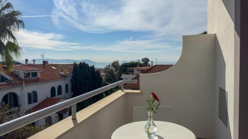 a vase with a flower on a table on a balcony at Hotel Marad in Torre del Greco
