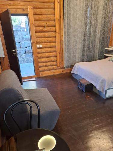 a room with a bed and a couch and a window at גן הדובדבנים in Odem