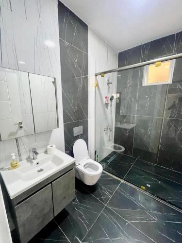 ein Badezimmer mit Waschbecken, Toilette und Dusche in der Unterkunft Aqua Luxury homes in Mombasa