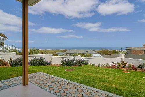 a view of a yard with a white fence and grass at The View, Studio in Hermanus