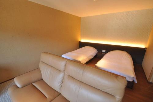 a living room with a couch and two beds at Aura Tachibana in Hakone
