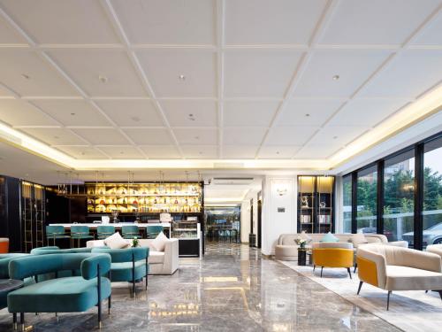 a lobby of a hotel with couches and chairs at Pazhou XANA Deluxe International Hotel Pazhou Convention and Exhibition Center Nanzhou Metro Station Branch - Free Shuttle Bus to Canton Fair Complex During Canton Fair Period in Guangzhou