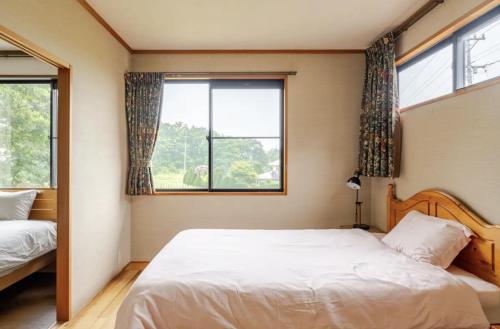 a bedroom with two beds and two windows at Foresta Karuizawa 3 in Miyota