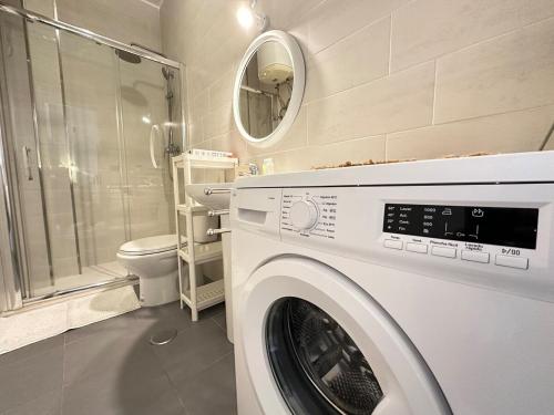 eine weiße Waschmaschine in einem Badezimmer mit Toilette in der Unterkunft YBH Doctor Cadaval 10 A in Vigo