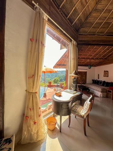 a living room with a table and a large window at Phu Chaisai Chiang Rai Mountain Resort in Mae Salong Nai