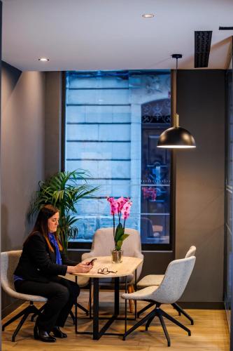 a woman sitting at a table in a room at ibis budget Logroño Centro in Logroño