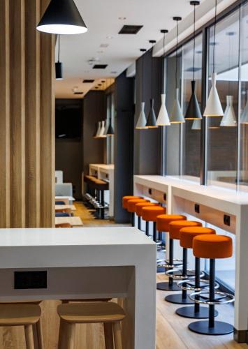 an office with white tables and orange stools at ibis budget Logroño Centro in Logroño