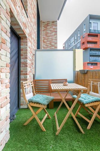 a picnic table and chairs on a patio with a whiteboard at Le Duplex des Docks by So Homy - 2 Bed Room - 4 PAX in Saint-Ouen