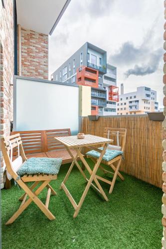 d'une table et de chaises sur un balcon avec un tableau blanc. dans l'établissement Le Duplex des Docks - 2BR - 4PAX, à Saint-Ouen